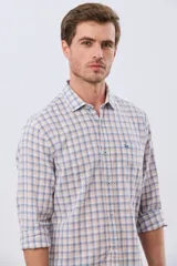 Camisa de lino con diseño a cuadros en tonos celestes y rosados, de manga larga, con cuello camisero, cierre frontal de botones y un bolsillo aplicado en el pecho con logo bordado.