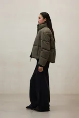 Campera acolchada negra, estilo puffer, con cuello alto y cierre frontal. Diseño oversize.