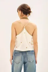 Top de tirantes finos color crema, con escote redondo y detalles de bordados dorados con hilos de lurex en la parte frontal.