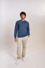 Buzo de cuello redondo en color azul, con mangas largas y puños acanalados. Presenta un pequeño logo bordado en el pecho.