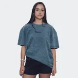 Remera de corte oversize con efecto de lavado ácido en color azul, presenta un estampado pequeño en el centro del pecho con la palabra Relajo.