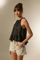 Top negro de cuello halter con frunces, diseño holgado y corte cropped con volado en el ruedo.