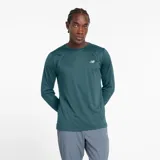 Remera de manga larga New Balance, color verde azulado, con cuello redondo y logo reflectante en el pecho. Confeccionada en tejido transpirable y ligero, con dobladillo trasero más bajo y aberturas laterales.
