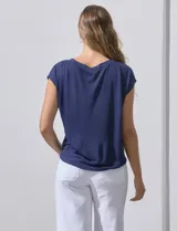 Blusa color beige de modal con escote en V, abertura central con botones y ruedo anudado. Marca French Laundry.