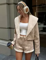 Conjunto de chaqueta corta color beige con cuello de piel sintética y short a juego.