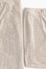 Pijama de dos piezas de punto suave, color beige melange, compuesto por un top de tirantes finos ajustables con detalles de encaje en el escote y un short corto con cintura elástica.