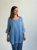Sweater de punto color azul jean, con cuello redondo, mangas largas con vuelta y diseño amplio de corte evasé.