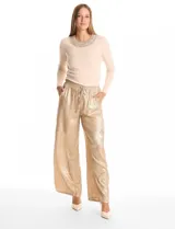 Pantalón wide leg de tela laminada metalizada color dorado, con pretina elástica y lazo de ajuste en la cintura. Cuenta con bolsillos laterales.