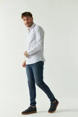 Camisa de hombre de corte slim fit, confeccionada en algodón con diseño de rayas verticales finas en tonos claros. Presenta cuello clásico, cierre frontal con botones y logo bordado en el pecho.