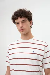Remera de manga corta con diseño de rayas horizontales y cuello redondo. Confeccionada en algodón jersey lavado de textura suave, presenta un pequeño detalle bordado en el pecho.