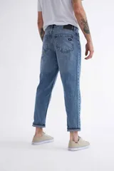 Pantalón jean celeste de corte mom, con tiro alto y tobillos ajustados.