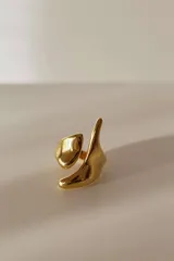 Anillo dorado de acero quirúrgico hipoalergénico, abierto y ajustable entre 16 mm y 19 mm, con diseño asimétrico y forma orgánica.