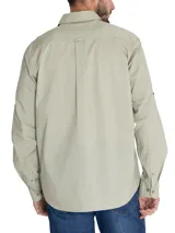 Camisa manga larga color verde oliva, confeccionada en popelina 100% algodón orgánico. Cuenta con cuello camisero, cierre frontal con botones de madera, bolsillo en el pecho con logo bordado y mangas ajustables con botones.