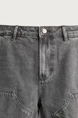 Bermuda relaxed fit color marrón con efecto lavado, cinco bolsillos, bolsillos frontales de carpintero y cierre frontal con cremallera y botón.
