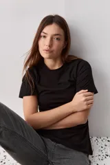 Remera negra de manga corta, con cuello redondo y diseño de corte recto.