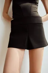 Shorts mini de tiro bajo y diseño ajustado, con cierre lateral con cremallera oculta en costura.