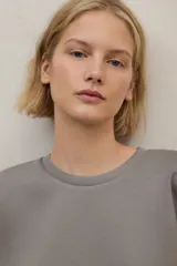 Buzo de cuello redondo, manga larga con puños elásticos y ruedo con banda elástica. Presenta un diseño minimalista y holgado.