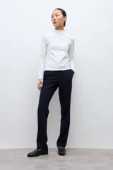 Media polera de manga larga con cuello alto y detalle de frunces en los puños, confeccionada en tejido suave y elástico.