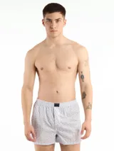 Bóxer de algodón blanco con estampado de flores pequeñas color celeste, con cintura elástica y logo de la marca en el centro.