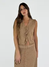 Chaleco blanco tejido en lino con escote en V y cierre frontal con lazos.