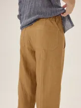 Pantalón de lino y poliéster color blanco, de corte holgado estilo barrel con costuras decorativas y bolsillos laterales.