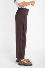 Pantalon de corte baggy y tiro medio, color marrón oscuro, con diseño de pierna ancha y bolsillos laterales.