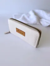 Billetera grande de cuero color crudo con cierre metálico y monedero interno.