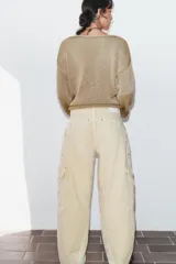 Jeans de tiro medio con diseño cargo, bolsillos de plastrón y pernera holgada que se estrecha hacia el tobillo. Cierre frontal con cremallera y botón.
