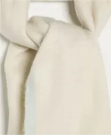 Bufanda manta de tejido suave y peluche, color celeste claro, con flecos largos en los extremos de color beige.