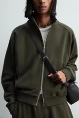 Sudadera de algodón con interior en rizo afelpado, cuello subido, manga larga y cierre frontal de cremallera. Presenta un efecto lavado que le da una apariencia única y bolsillos frontales ocultos en las costuras.