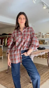 Camisa de manga larga con estampado a cuadros en tonos bordó y gris, de corte oversize y con bolsillos frontales con solapa.