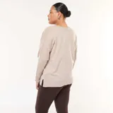 Sweater de punto fino en color beige, con escote en V, mangas largas y diseño holgado con aberturas laterales en el ruedo.