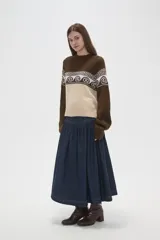 Sweater de tejido de punto con diseño jacquard, cuello redondo y mangas largas. Presenta una combinación de bloques de color azul marino y celeste con un patrón geométrico en la parte superior.