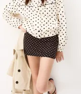 Short pollera deportivo negro con estampa de lunares blancos, confeccionado en microfibra con cintura alta y short interno integrado.