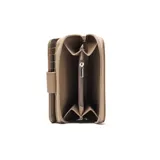 Billetera de tamaño mediano confeccionada en material símil cuero con textura granulada. Presenta un cierre perimetral y una solapa frontal con broche a presión decorada con una flor en relieve y el logo metálico de la marca.