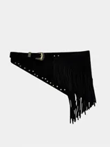Faja negra de cuero con flecos colgantes, detalles de tachas metálicas doradas a lo largo del borde y hebilla metálica de inspiración western.