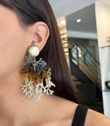 Aros colgantes con forma de coral hechos a mano con mostacillas de colores dorado, plateado, negro y blanco.