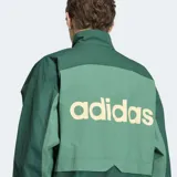 Campera deportiva Adidas Múnich 93 en tonos de verde, con cuello alto, cierre frontal y las icónicas tres tiras en las mangas. Diseño holgado con detalles en contraste.