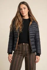 Campera reversible con diseño acolchado, cierre frontal y capucha. Un lado es de color negro y el otro de color tostado, con puños tejidos en color negro.