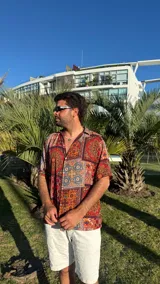 Camisa de manga corta con estampado de mosaicos en tonos rojo, naranja, azul y blanco.