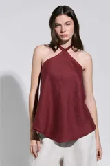Top bordó con cuello halter cruzado y bordes deshilachados, de corte acampanado y caída suave.