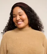 Suéter color beige de punto con textura de pelitos, cuello alto y mangas largas.