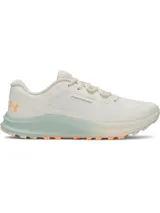 Championes de trail running Under Armour Charged Bandit TR 3, color beige con detalles en verde agua y naranja. Presentan una parte superior de malla transpirable con refuerzos estratégicos, entresuela Charged Cushioning para mayor amortiguación y suela con tacos técnicos para tracción en terrenos irregulares.