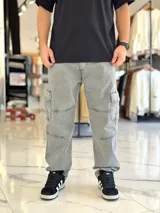 Pantalón cargo de jean azul con múltiples bolsillos en los laterales y diseño holgado.