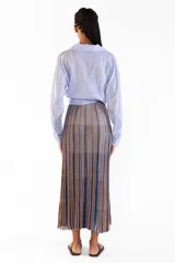 Camisa de manga larga color celeste, confeccionada en algodón, con cuello clásico, cierre frontal de botones y diseño cruzado con lazo para anudar en la cintura.