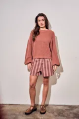 Sweater de tejido bouclé texturado color beige, con cuello redondo y mangas largas holgadas de corte amplio.