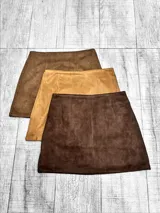 Pollera con short integrado de diseño minimalista, confeccionada en gamuza sintética con textura suave. Presenta un corte recto y tiro medio.