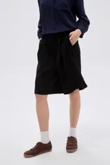 Short ancho de poliéster color negro, de tiro alto y diseño sastrero con pinzas en el frente.