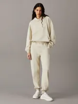 Pantalón de chándal de felpa de algodón orgánico, color beige claro, de corte regular con cintura elástica y puños de canalé.