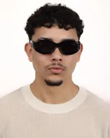 Lentes de sol negros con forma ovalada y patillas gruesas.